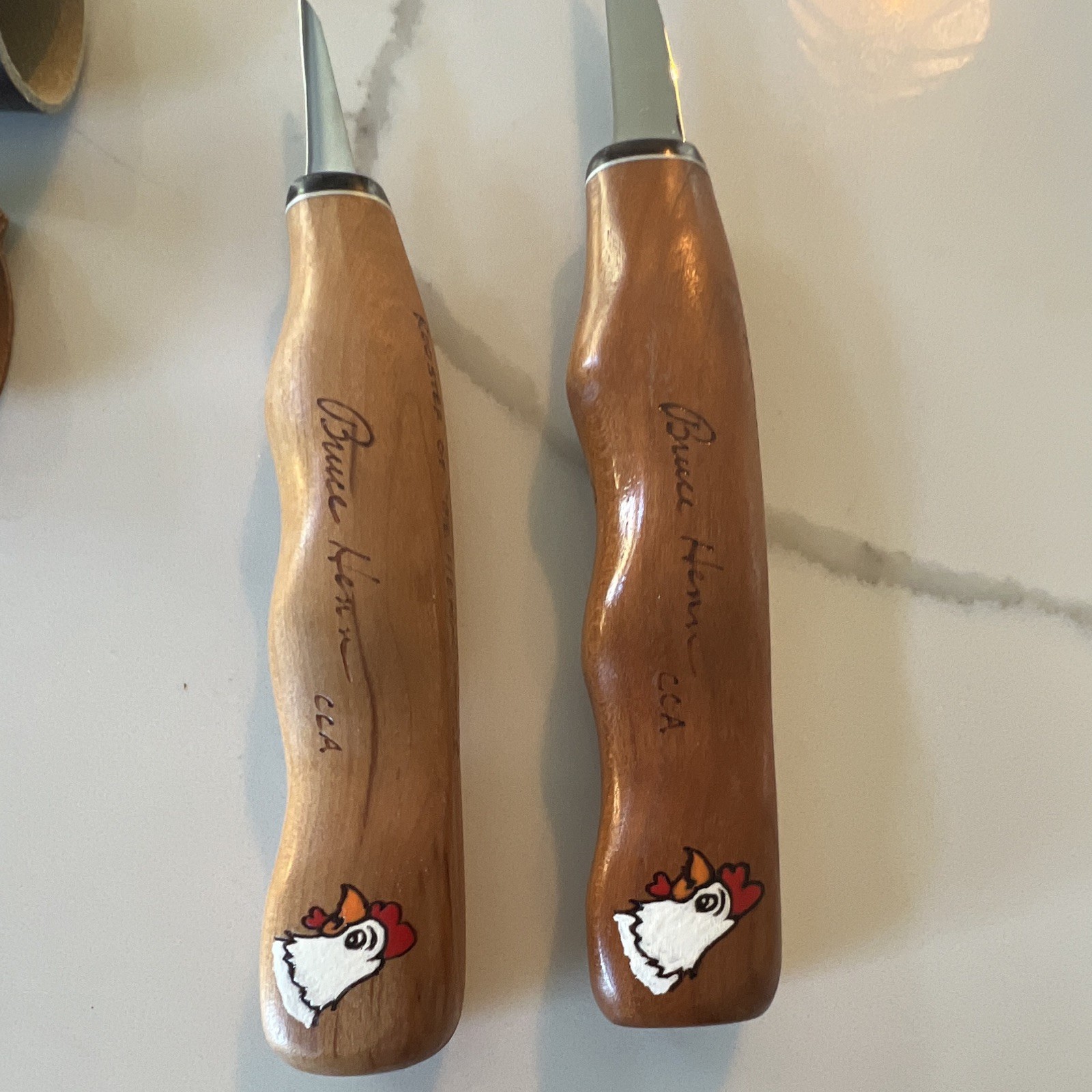 Set of 2 Bruce Henn Helvie Wood cutting knives with signature painted Rooster.